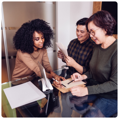 A group of 3 people in a HR team working together at a table.