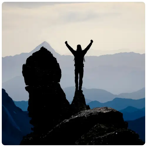 Silhouette of a person standing on a mountain peak — representing ambition, vision, and leadership at Salusphere Global.