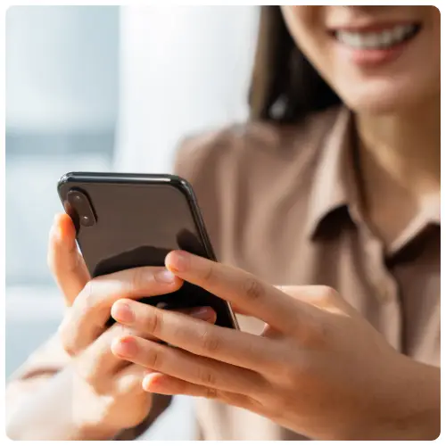 Woman holding a mobile phone, symbolising contacting or connecting with Salusphere Global.