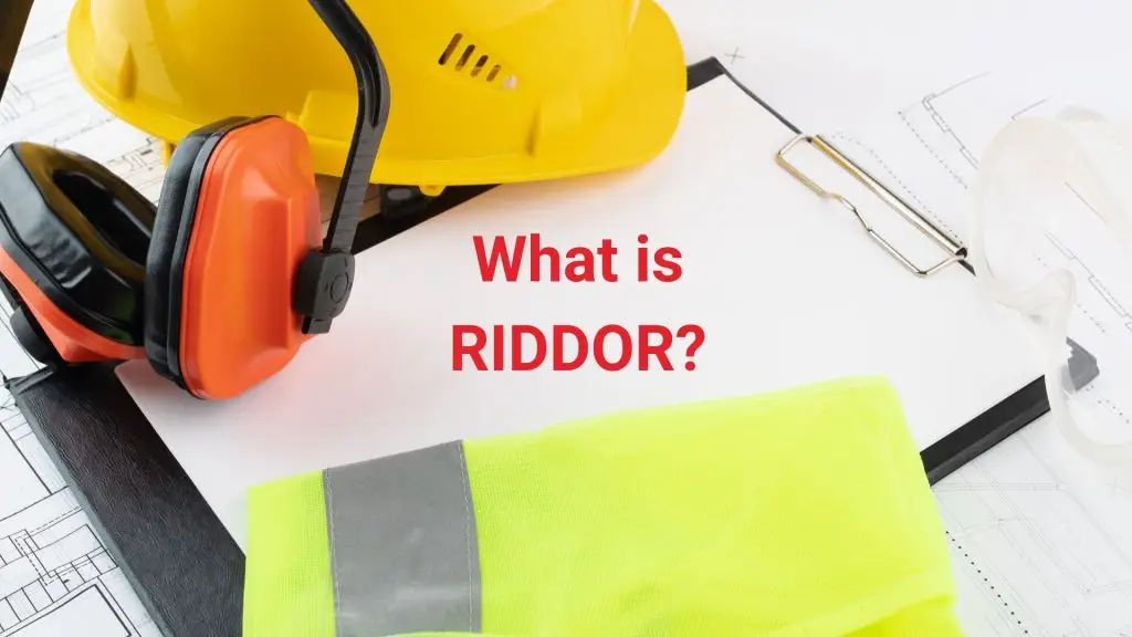 High-visibility vest, hard hat, and hearing protection laid on a clipboard — representing workplace safety and RIDDOR compliance.