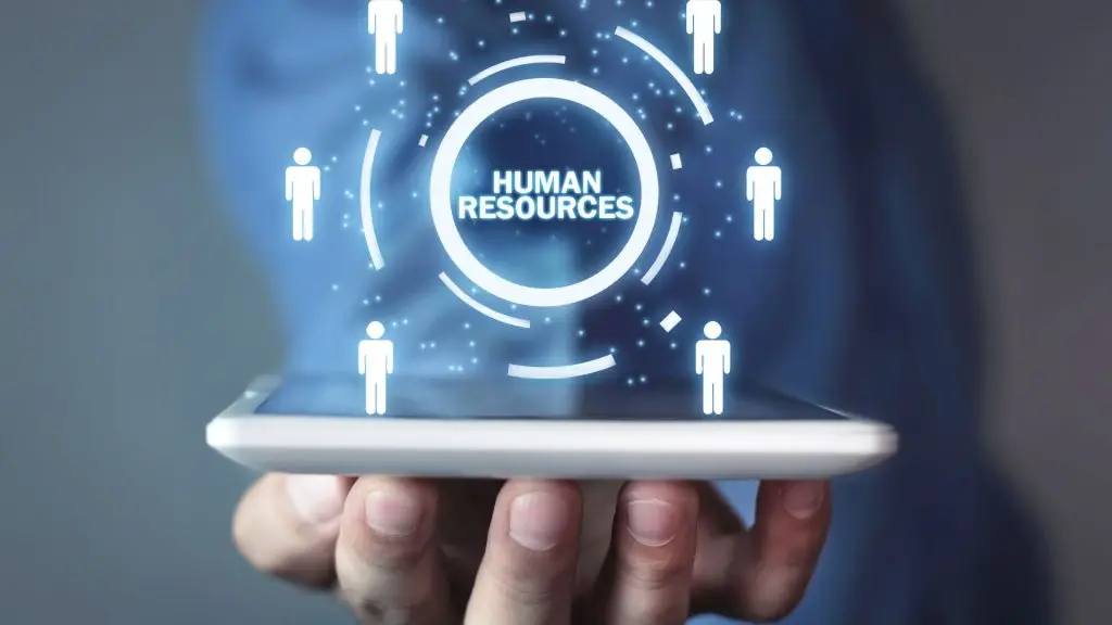 Hand holding a tablet displaying digital figures around a circle with “Human Resources” in the centre — representing HR management and support.