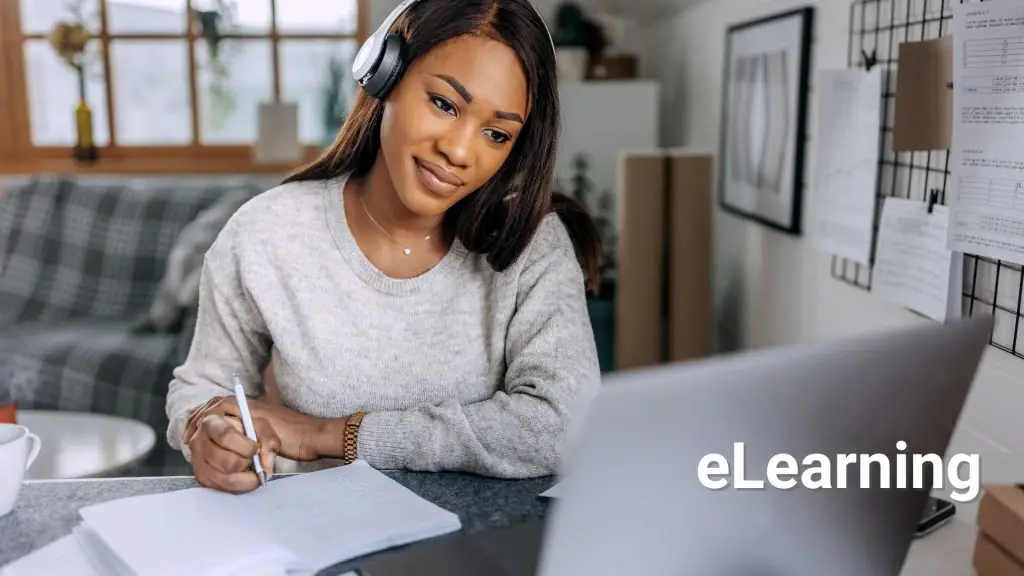 Woman using a laptop with headphones — representing online e-learning and digital training.