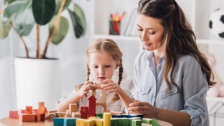 Mother and daughter playing with wooden blocks — representing support for parents of children with additional needs.