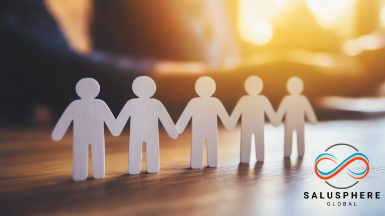 Paper cutout figures holding hands in sunlight, symbolising workplace unity, wellbeing, and positive organisational culture.